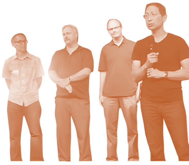 Four men standing one with a microphone - orange with white outlines